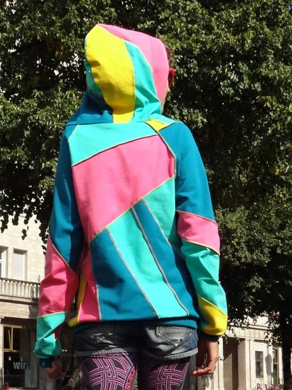 Rückansicht handgemachter Streetwear Hoodie in Türkis, Pink und Gelb. Mit großer Kapuze und Uv-aktiven Nähten. Gute Laune Unikat zum Anziehen